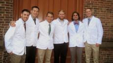 man with white coat and classmates